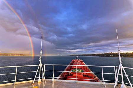 Colorful views of the rainbow against the sky, clouds and sea horizon. Commencement Bay, Tacoma, WA, USAの写真素材