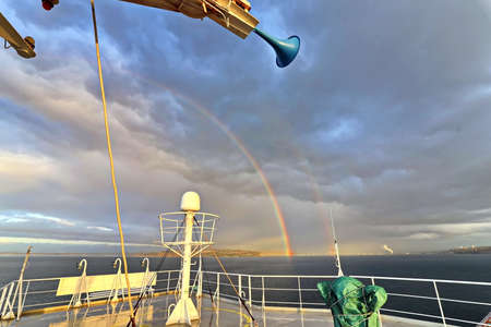 Colorful views of the rainbow against the sky, clouds and sea horizon. Commencement Bay, Tacoma, WA,...