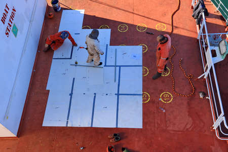 Tacoma, WA, USA, October, 23-25, 2019. MV Egyptian Mike. Repainting the ship's funnel and drawing the logo of the shipowner with members of the ship's crew.のeditorial素材