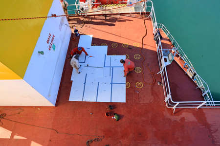 Tacoma, WA, USA, October, 23-25, 2019. MV Egyptian Mike. Repainting the ship's funnel and drawing the logo of the shipowner with members of the ship's crew.のeditorial素材