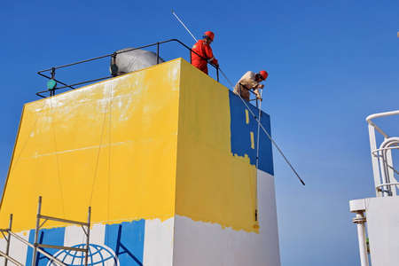 Tacoma, WA, USA, October, 23-25, 2019. MV Egyptian Mike. Repainting the ship's funnel and drawing the logo of the shipowner with members of the ship's crew.のeditorial素材