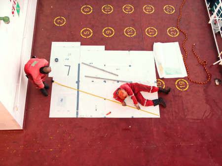 Tacoma, WA, USA, October, 23-25, 2019. MV Egyptian Mike. Repainting the ship's funnel and drawing the logo of the shipowner with members of the ship's crew.のeditorial素材
