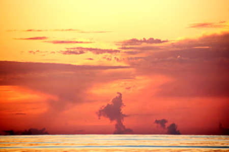 Sunset in the open ocean. Colorful views of the surface of the water and the sky with clouds over ocean.の写真素材