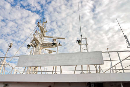 Ship structures, masts, antennas, funnel, ship wheelhouse against the blue sky and clouds.の写真素材