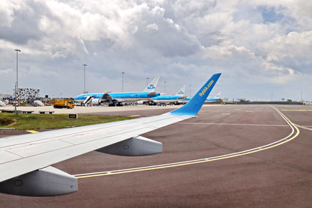 Amsterdam, Netherlands. 18 August 2020. Airport terminal. Plane landing and taxiing to the place of disembarkation of passengers.のeditorial素材