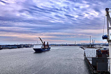 Port of Taichung, Taiwan. September, 24, 2020. Seagoing vessels, tugboats at the port under cargo operations and underway.のeditorial素材
