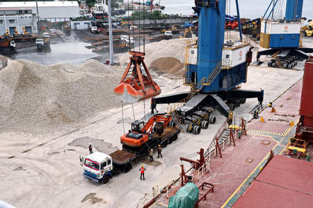 Paradeep, India, October, 21, 2020. Cargo terminal for unloading bulk cargo of limestone by shore cranes and grabs. Views of cargo equipment for discharging of bulk cargoes.のeditorial素材