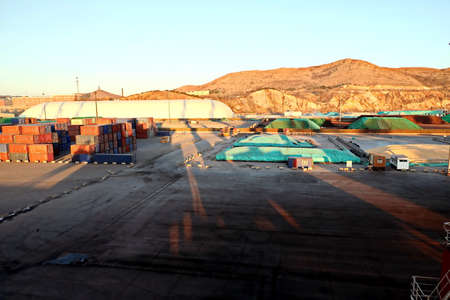 Cargo terminal for unloading bulk cargo of iron ore by shore cranes and grabs. Huludao, China.