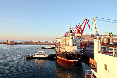Seagoing vessels, tugboats at the port under cargo operations and underway in the port of Huludao,...