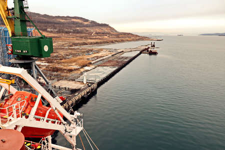Port of Vostochnyy. Russia, December, 08, 2020. Cargo terminal for loading steel plates into bulk carrier by shore cranes.のeditorial素材
