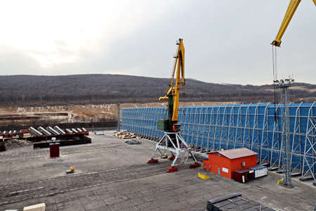 Port of Vostochnyy. Russia, December, 08, 2020. Cargo terminal for loading steel plates into bulk...