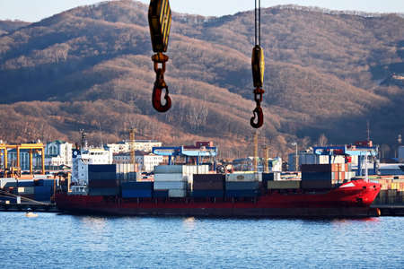 Container vessels, bulk carrier and tugboats at the port under cargo operations and underway. Port of Vostochnyy. Russia, December, 2020の写真素材