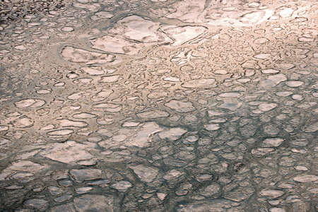 The sea water surface of the ocean with ice presence in winter weather as a background.