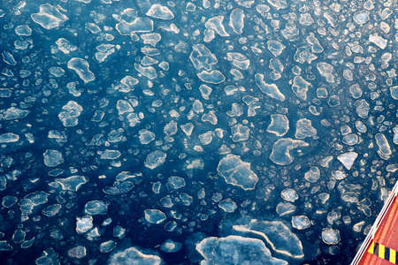The sea water surface of the ocean with ice presence in winter weather as a background.の写真素材