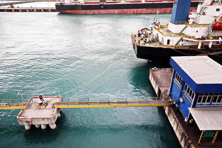 Cargo terminal for unloading steel plates from bulk carrier by ships cranes. Port of Cigading. Indonesia, December, 2020.の写真素材