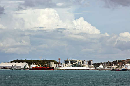 Vessels, bulk carrier and tugboats at the port under cargo operations and underway. Port of Cigading, Indonesia, December, 2020の写真素材