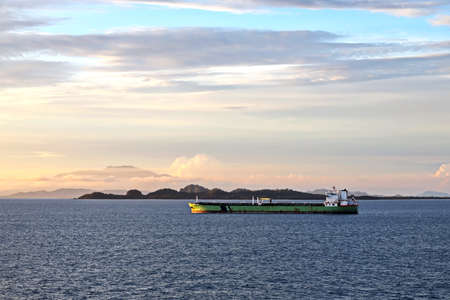 Vessels, bulk carrier and tugboats at the port under cargo operations and underway. Port of Cigading, Indonesia, December, 2020の写真素材