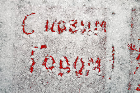 Inscription Happy New Year 2022 and Marry Christmas on natural snowy surface in wintertime. Text, winter holiday background with copy space on snow. hand writing, text,の写真素材