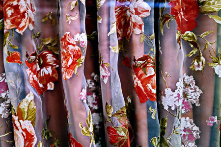 Fabric with floral pattern in the shop window. close up.