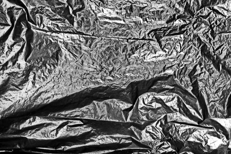 Crumpled black plastic sheet. Abstract background and texture for design.の写真素材