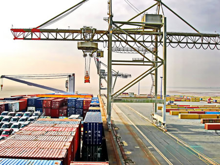 Container Cargo freight ship with working crane bridge for Logistic Import Export background