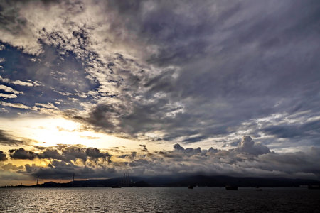 Dramatic sunset over the sea with clouds and islands in the backgroundの写真素材