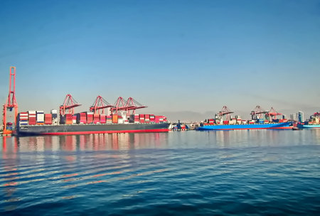 Container Cargo freight ship with working crane bridge for Logistic Import Export backgroundの写真素材