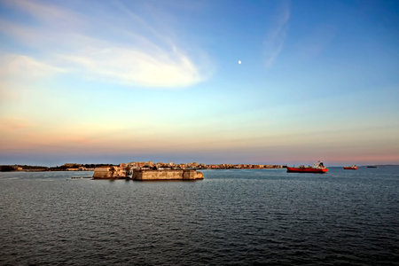 Fishing boats in the bay of the island of Malta at sunsetの写真素材