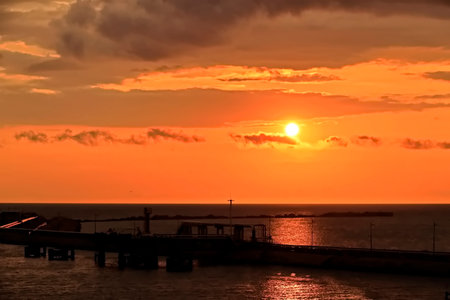 Beautiful sunset over the sea with the silhouette of a pier.の写真素材