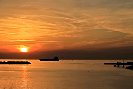 Beautiful sunset at the sea with ships in the background. Silhouettes of ships at sunset.の写真素材