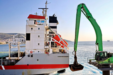 Cargo terminal for loading bulk cargo of iron ore by ship cranes and grabs. Views of the cargo...
