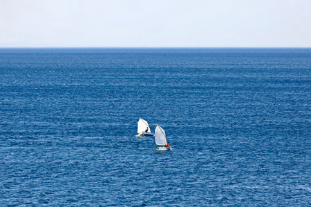 Sailboat in the sea on a background of blue sky.
