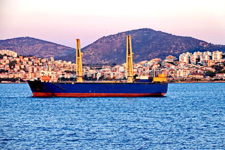 A cargo ship in the sea against the backdrop of the city.の写真素材