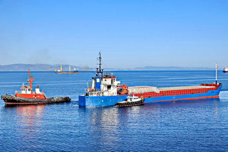 Tugboat assisting bulk cargo ship to harbor quayside, Norwayの写真素材