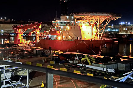 Cargo terminal for loading bulk cargo of iron ore by ship cranes and grabs. Night view.の写真素材