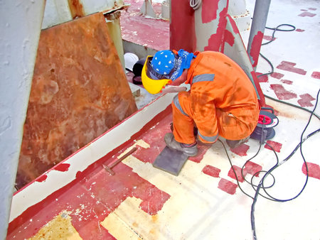 Welder working on the construction site of a new oil rig.