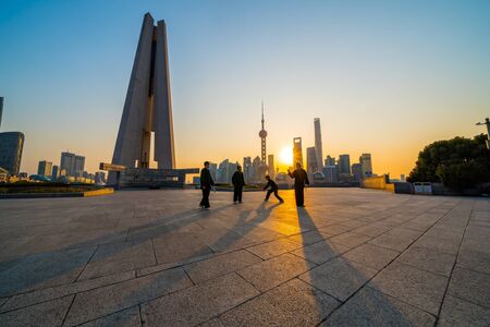 Shanghai, China - February 6, 2018: People playing Tai Chi on the Bund at sunrise, Oriental Pearl...
