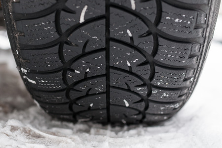 Closeup of Winter tyre on the road covered with snowの写真素材