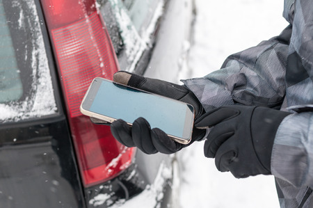 Driver calling with phone for help on the road in winterの写真素材