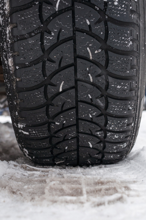 Winter tyre on the road covered with snowの写真素材