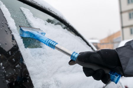 Man Cleaning Car Window From Snow and Iceの写真素材