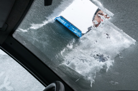 Man Cleaning Car Windshield From Snow and Iceの写真素材