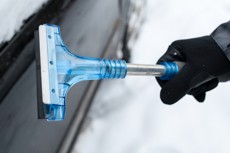 Closeup of man hand with snow and ice car cleanerの写真素材