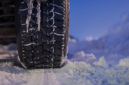 Winter tyre on the road with snowの写真素材