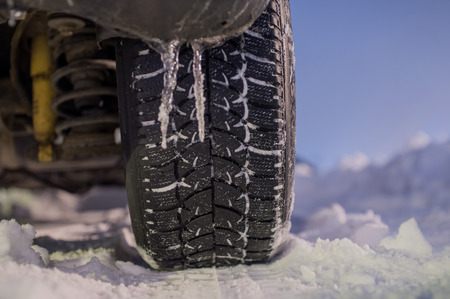 Winter tyre on the road with snowの写真素材