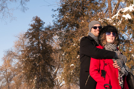 Happy Couple enjoying in beautiful sunny winter day Outdoors. Snow. Winter Vacation.の写真素材