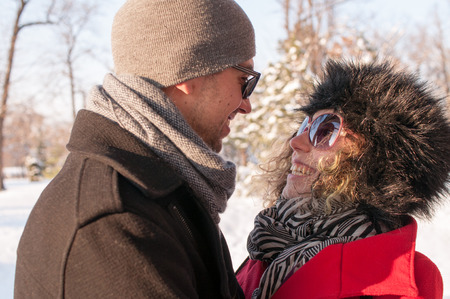Couple Laughing In The Park Together in winter on snowの写真素材