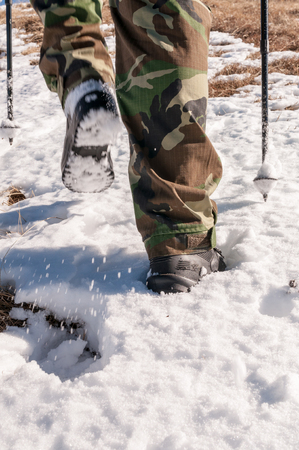 Low section rear view of an unrecognizable man hiking on the snowの写真素材