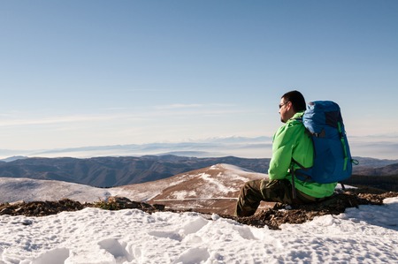 Hiker relaxing on top of hill and enjoying on sunny dayの写真素材