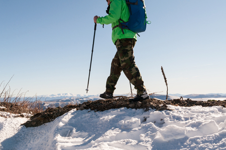 Mid section of a male backpacker walking on mountain peak.の写真素材